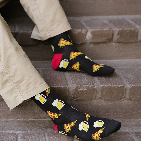 A man wearing Xl socks with pizza slices and mugs of beer
