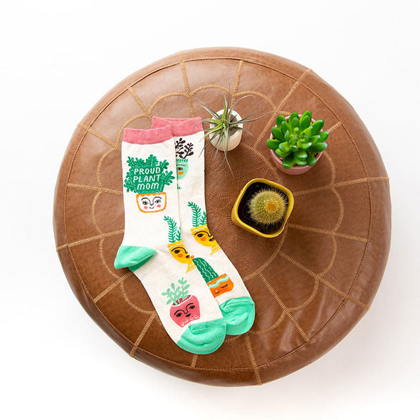 Proud Plant Mom socks surrounded by potted plants
