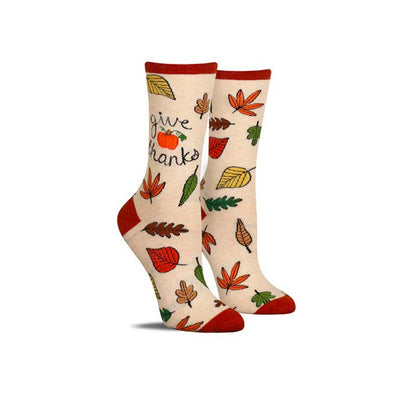 Colorful, cute fall socks with a variety of falling leaves and the words “give thanks”.