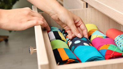 woman opening drawer with different colorful socks