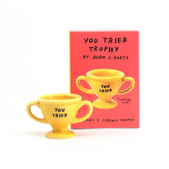 Alternate view of tiny yellow trophy that says, “You tried”