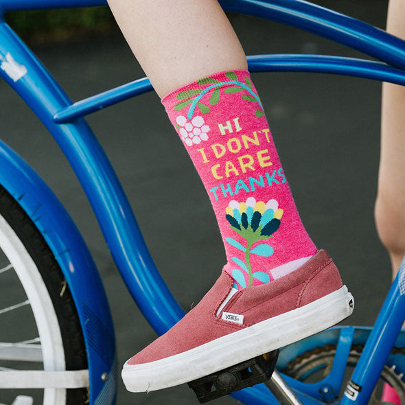 woman on a bicycle wearing sassy socks that say "Hi I Don't Care Thanks"