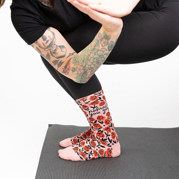 A woman doing yoga wearing Namaste You Guys socks