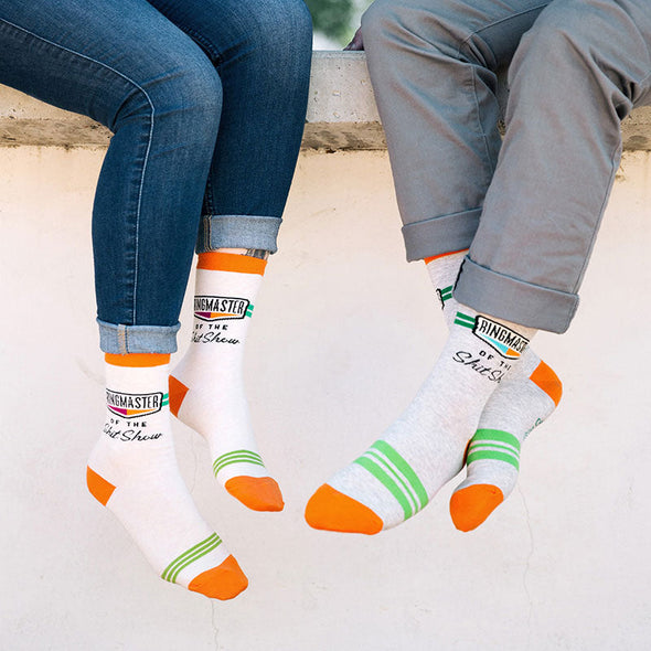 Two people wearing matching Ringmaster of the Shit Show socks