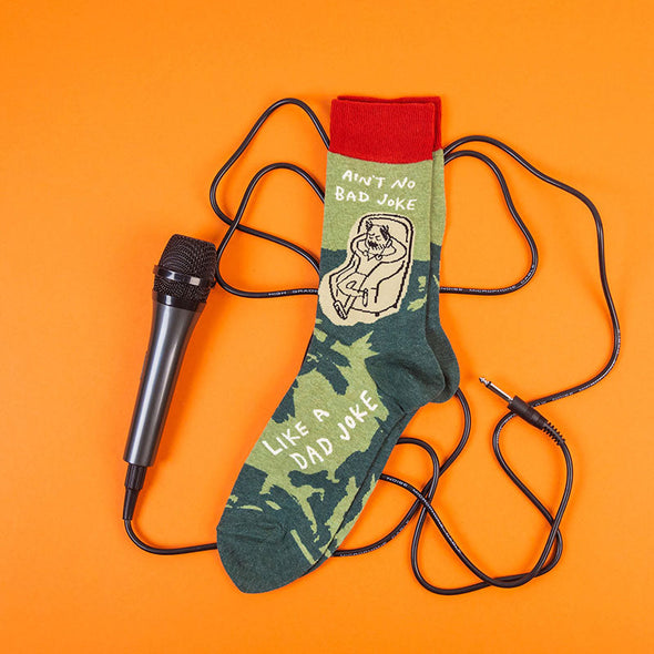 funny men's dad joke socks next to a microphone