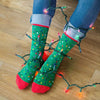 A woman wearing fun holiday socks featuring a pattern of Christmas lights