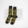 cool men's music socks with a pattern of musical instruments, lying on top of sheet music