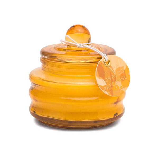 Scented candle in a small yellow-orange glass jar with lid
