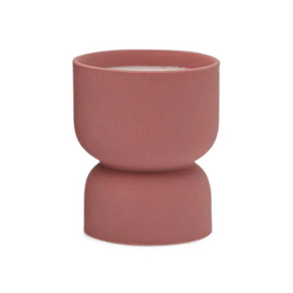 Scented candle in a matte rose-colored ceramic vessel