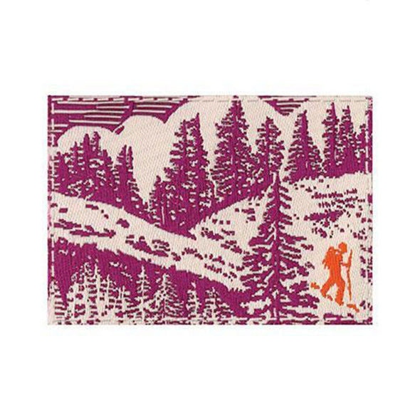 A close-up view of the second tag that has a pattern of trees and a hiker