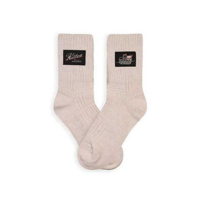 Textured white women’s socks with a small tag that says, “Kitten in a basket”