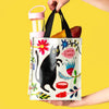 person holding a small handled tote bag with an image of a cat and the words "chow time"