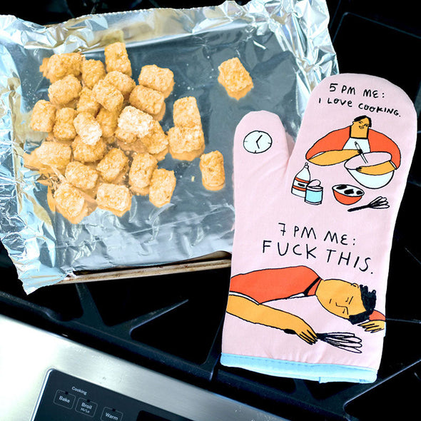 funny, R-rated oven mitt next to a sheet of tater tots