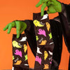 cool witch holding up fun Halloween socks with a pattern of colorful ghosts and the word "Boo!"