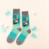 Funny men’s beer socks laying flat next to mini beer pong cups and ping pong balls