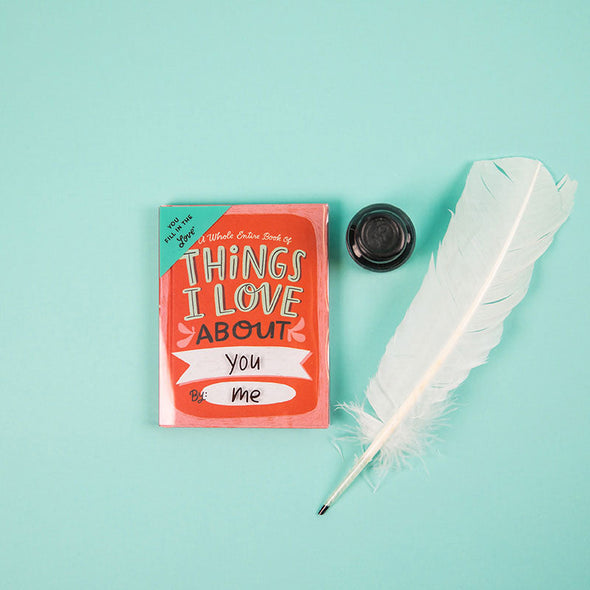 Blank book that says, "Things I Love About You" alongside a quill pen and an inkpot