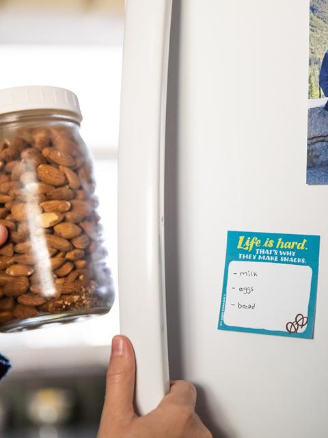 refrigerator, snacks, and a sticky note that says "Life is hard. That's why they make snacks."