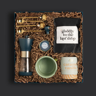 Goodly curated gift box with gourmet coffee beans, a grinder and other items for coffee lovers