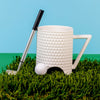 funny golf-themed mug sitting on astroturf
