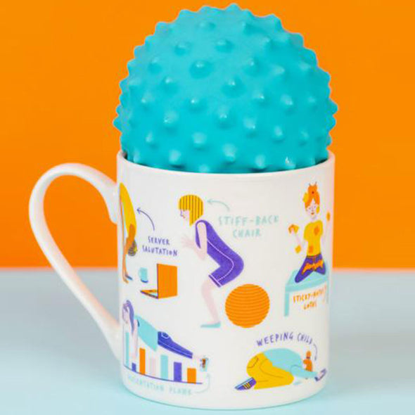 massage ball sitting in a yoga-themed mug