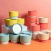 Assorted colors of scented candles in color blocked ceramic containers 