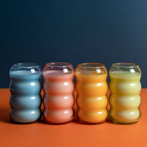 Assorted colors of scented candles in ribbed glass containers 