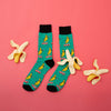 Funny banana food socks for men laying flat next to bananas
