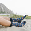 A man wearing animal socks with otters holding paws