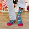 A man wearing funny Christmas socks with reindeer humping in an ugly sweater pattern