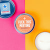 colorful view of funny candle tin that says, "fuck this meeting"